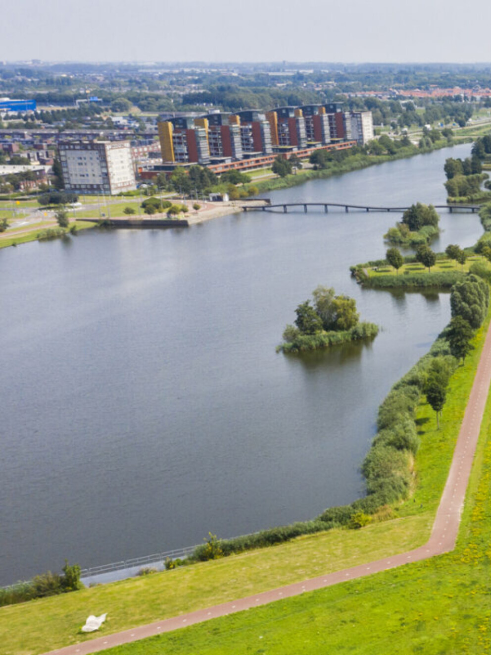 Luchtfoto van een rivier met dijk en ernaast een lager gelegen polder