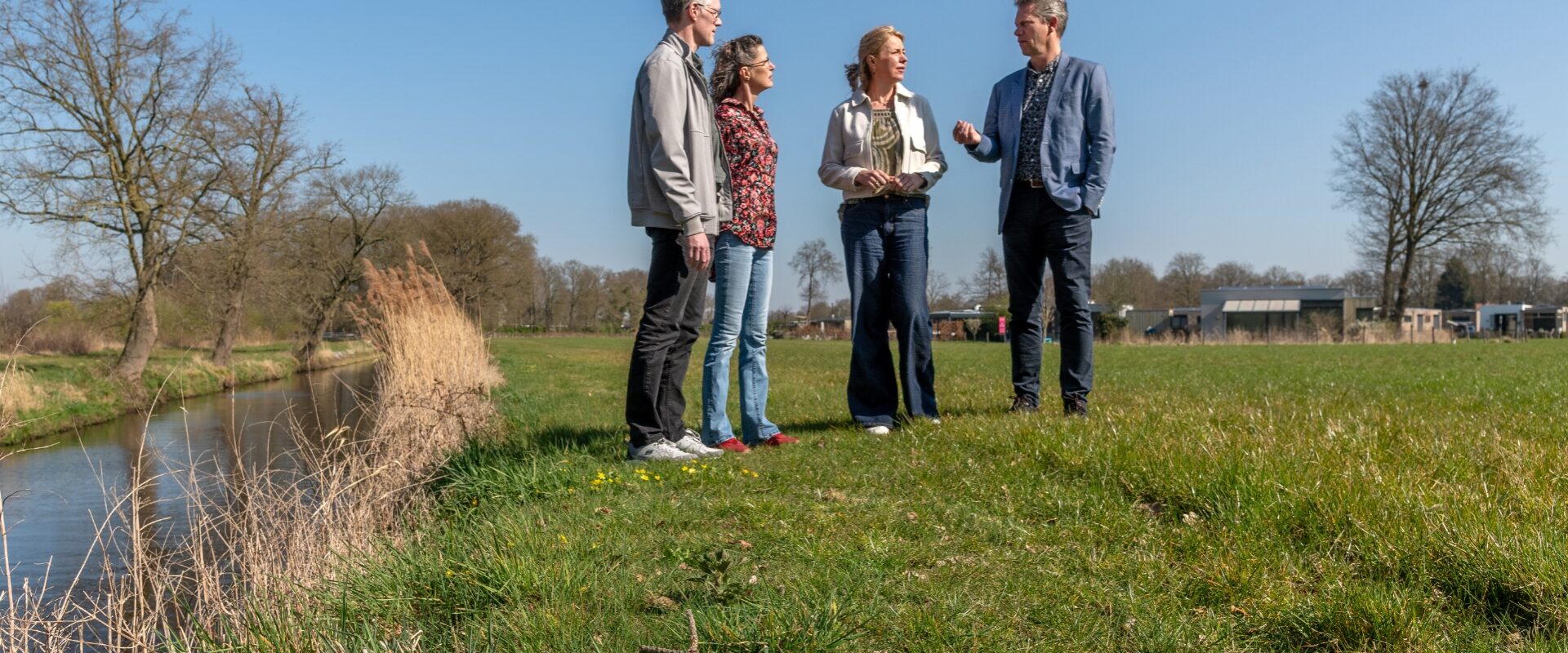 Henk, Ingeborg en Joost van Waterschap De Dommel in gesprek met bewoner Heidi.