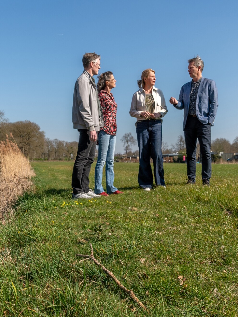 Henk, Ingeborg en Joost van Waterschap De Dommel in gesprek met bewoner Heidi.