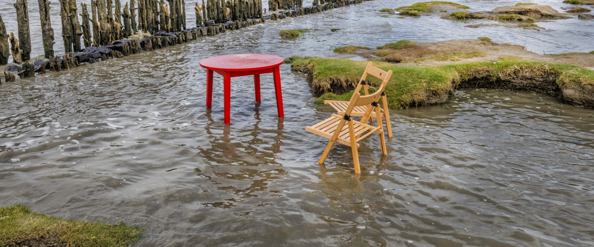 Stoel en tafel in hoog water bij Moddergat