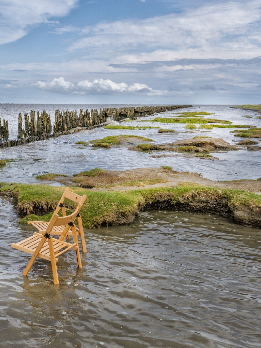 Stoel en tafel in hoog water bij Moddergat